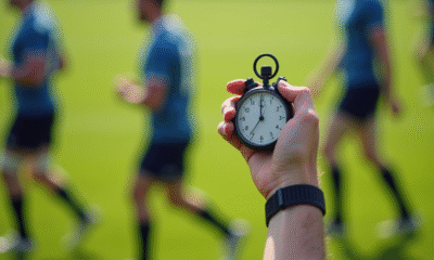 Arbitre rugby levant un chronometre sur terrain vert