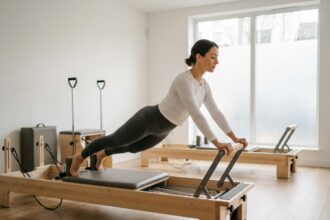 Femme pratiquant le pilates sur reformer dans un studio épuré au quartier Monceau à Paris